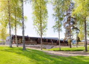 a building in the middle of a park with trees at Chalet Ellivuori huoneisto as 1 in Sastamala