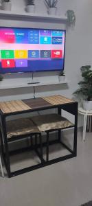 uma televisão em cima de uma prateleira com uma mesa em Your home in the city em Manilla