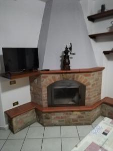 ein Wohnzimmer mit einem Kamin und einem Flachbild-TV in der Unterkunft Casa Isidora in Acquaviva