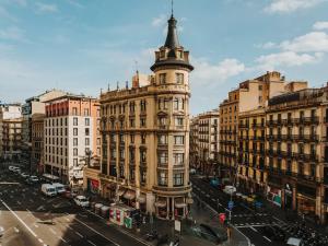 ein hohes Gebäude mit einem Kirchturm an einer Stadtstraße in der Unterkunft Sonder Casa Luz in Barcelona