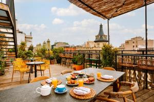 a table with food on a balcony with a view at Sonder Casa Luz in Barcelona