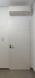 pared blanca con puerta en una habitación en Departamento PALU en Tandil