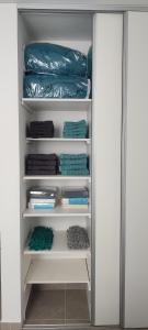 un armario lleno de toallas verdes en Departamento PALU en Tandil