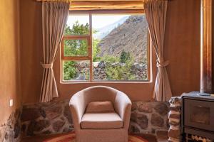 sala de estar con silla y ventana en Unuwasi Hotel & Villa en Calca