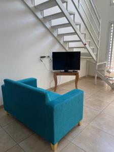 sala de estar con sofá azul y TV en Hermoso Departamento Tipo Loft -Mendoza en Godoy Cruz