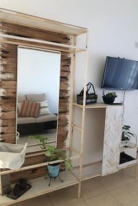 Habitación con espejo y TV en un estante. en LaCasita SP en San Pedro