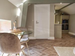 Habitación con mesa, sillas y cocina. en Little Hive-uk39430, en Dronfield