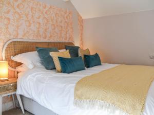 um quarto com uma grande cama branca com almofadas azuis em Little Hive-uk39430 em Dronfield