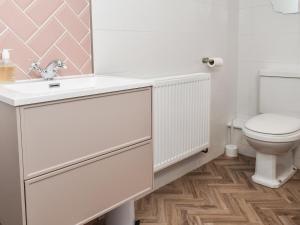 uma casa de banho com um lavatório branco e um WC. em Little Hive-uk39430 em Dronfield