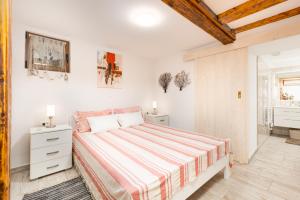 a white bedroom with a bed and a bathroom at Apartment VOLTE in Punat