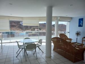 a dining room with a table and chairs and a pool at Departamento super cómodo Playa Naplo in Naplo