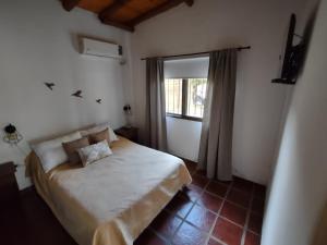 a small bedroom with a bed and a window at Altos del Campo in San José