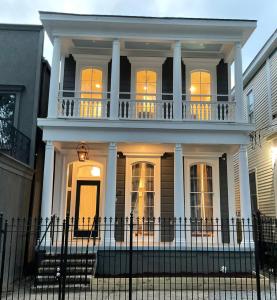a white house with a balcony on top of it at Canal Street Mini Mansion Sleeps 15 in New Orleans