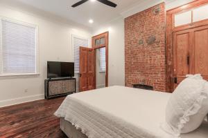 a bedroom with a bed and a brick wall at Canal Street Mini Mansion Sleeps 15 in New Orleans