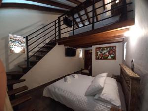 a bedroom with a bed and a staircase at Hostal La Casita de Toñito in Villa de Leyva