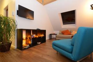 a living room with a blue couch and a tv at Kleine Villa in Trier