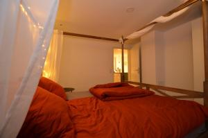 1 Schlafzimmer mit 2 Betten und orangefarbener Bettwäsche in der Unterkunft Kleine Villa in Trier