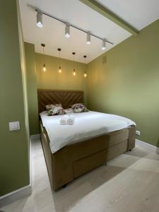ein Schlafzimmer mit einem großen Bett mit grünen Wänden in der Unterkunft Люкс Исы-Байзакова 133 by Slissenko Inn, Новый дом in Pawlodar