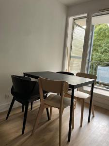une table à manger avec deux chaises et une fenêtre dans l'établissement Le Bon Quai, à Grenoble