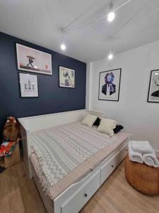 - une chambre dotée d'un lit avec un mur bleu dans l'établissement Le Bon Quai, à Grenoble