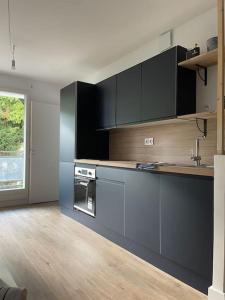 une cuisine avec des armoires noires et un comptoir dans l'établissement Le Bon Quai, à Grenoble