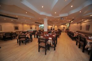 a restaurant with tables and chairs and people sitting at them at Jullundur Hotel & Restaurant in Chandīgarh