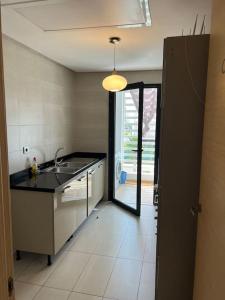 uma cozinha com um lavatório e uma porta para um pátio em Superbe appartement avec piscine em Rabat