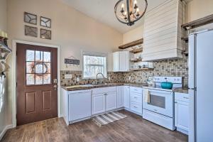 una cucina con armadi bianchi e una porta marrone di Gray Home with View of Boone Lake and Fire Pit! 