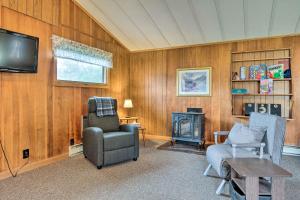 Cozy New Hampshire Cottage with Deck! في فرانكونيا: غرفة معيشة مع تلفزيون وكرسي وطاولة