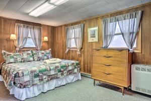 a bedroom with a bed and a dresser and windows at Cozy New Hampshire Cottage with Deck! in Franconia