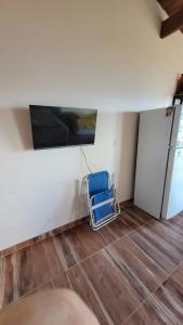 a blue chair in a room with a refrigerator at Astrolabio Hostel in San Carlos de Bariloche