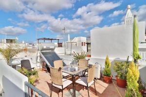 a patio with a table and chairs on a balcony at Zenit charm Olhao relax cubist House in Olhão