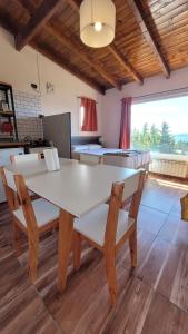 una sala da pranzo con tavolo e sedie bianchi di Astrolabio Hostel a San Carlos de Bariloche