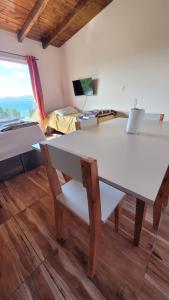 a white table and bench in a room with a bed at Astrolabio Hostel in San Carlos de Bariloche