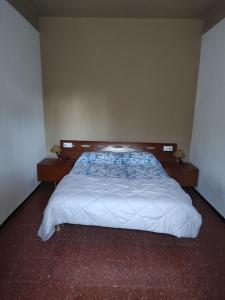 a bedroom with a white bed with a wooden headboard at Apartamentos Can bruguera 2 in Mataró