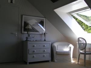 - une chambre avec une commode blanche et une chaise dans l'établissement Villa Flore Chambres d'Hotes, à Ault