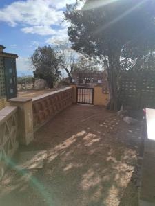 un cortile con recinto, cancello e albero di Apartamentos Can bruguera 2 a Mataró