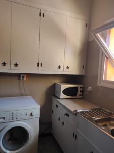 cocina con lavadora y microondas en Apartamentos Can bruguera 2, en Mataró