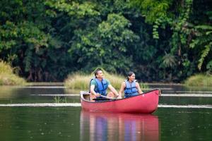 two people in a red boat in the water at Maquenque Ecolodge in Boca Tapada