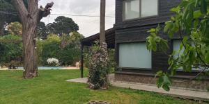 a black house with two windows and a tree at La Eugenia in Sierra de los Padres