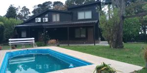 una casa con piscina frente a una casa en La Eugenia en Sierra de los Padres