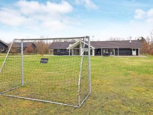 a soccer net in a field with a building at 14 person holiday home in H jslev in Sundstrup
