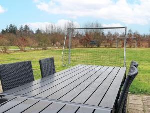 a wooden table with chairs and a soccer goal at 14 person holiday home in H jslev in Sundstrup