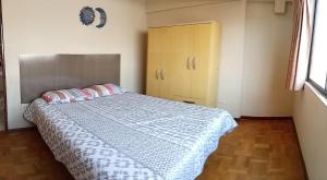 1 dormitorio con 1 cama con edredón azul y blanco en APARTAMENTO, CENTRO DE LA CUIDAD, en Cochabamba
