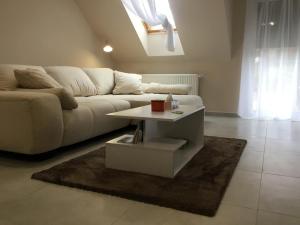 salon z białą kanapą i stołem w obiekcie Balance Apartman w Egerze +1 zdjęcie