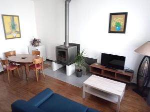 Gîte de l'Oustal في Oust: غرفة معيشة مع طاولة وموقد