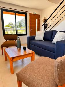 a living room with a blue couch and a table at Complejo Camino al Lago in Lago Puelo