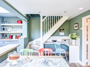 a kitchen and dining room with blue and green walls at Rose Cottage in North Elmham