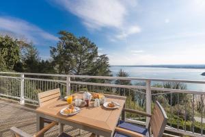 a table on a deck with a view of the water at Tremorna Vista in Carbis Bay