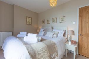 a bedroom with a large white bed with white pillows at Tremorna Vista in Carbis Bay